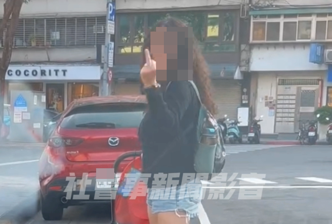 女子推嬰兒車人肉占車位，遭到驅趕時竟憤怒比出「中指」。（翻攝「社會事新聞影音」）
