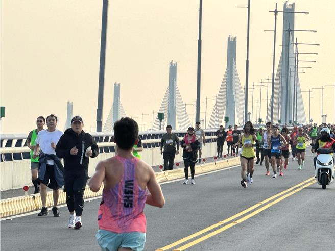 参赛选手相继奔向金门大桥，不过由于东北季风增强，桥上瞬间风力远超过7级，回程逆风跑起来更为吃力，不少选手大喊吃不消。(于家麒摄)