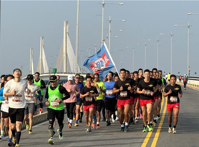 金防部海龙蛙兵也列队参加半马组竞跑，雄壮威武、精神抖擞的军容吸引不少跑者一路陪跑。(于家麒摄)