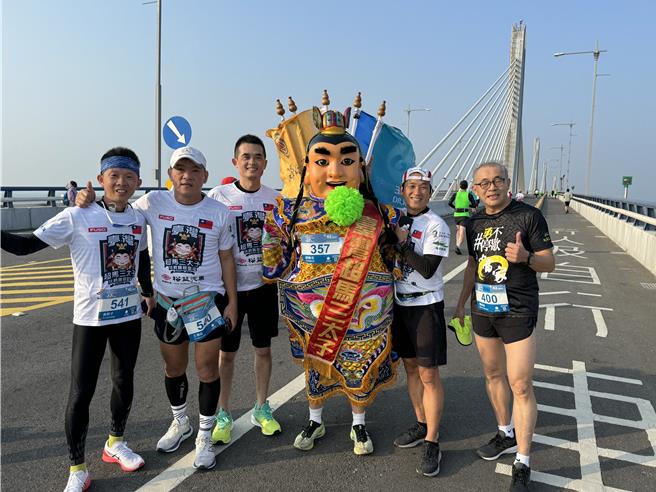 台湾超马三太子再次组团挑战金门马拉松，接力扛着太子爷跑完全马42K赛程。(于家麒摄)