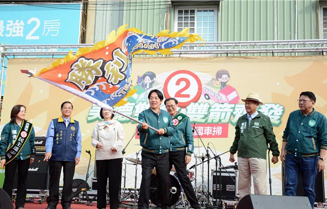 民进党总统候选人赖清德(前)8日在东港东隆宫前挥舞胜利旗帜，从屏东一路向北启动车扫。(林和生摄)