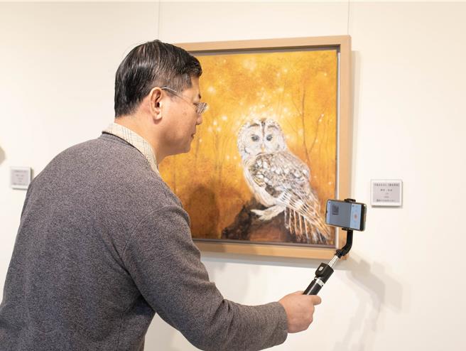 电子说明卡吸引赏画民眾，以相机纪录分享感想。（陈淑娥摄）