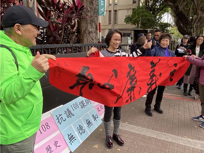 北一女中国文老师区桂芝（中）拿着「礼义廉耻」的布条，呼吁教育部修改108课纲。（林志成摄）