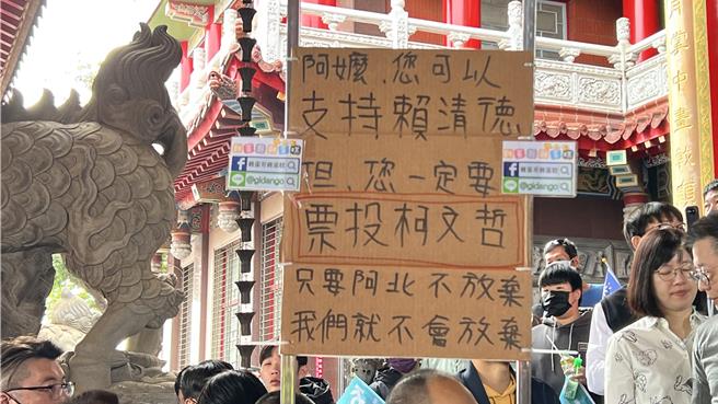 有支持者为了替柯文哲催出银髮族的票，制作手举牌并写着：「阿嬷，您可以支持赖清德，但一定要票投柯文哲」。（张毓翎摄）