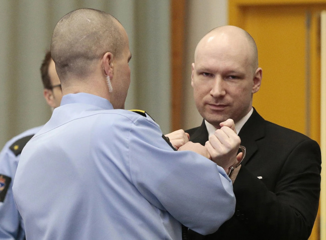 2016年，法庭上的布雷维克，法警谨慎的解开他的手铐。(图/美联社)