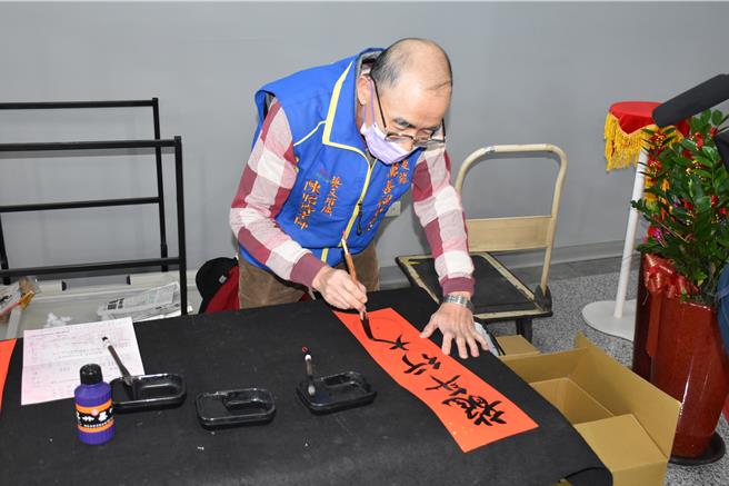 华山基金会后龙爱心天使站携手后龙镇公所及后龙镇代会，10日上午在后龙镇公所一楼大厅举办「寒冬送暖，舞动孤老心」活动，由书法老师替孤老们书写免费春联。（谢明俊摄）
