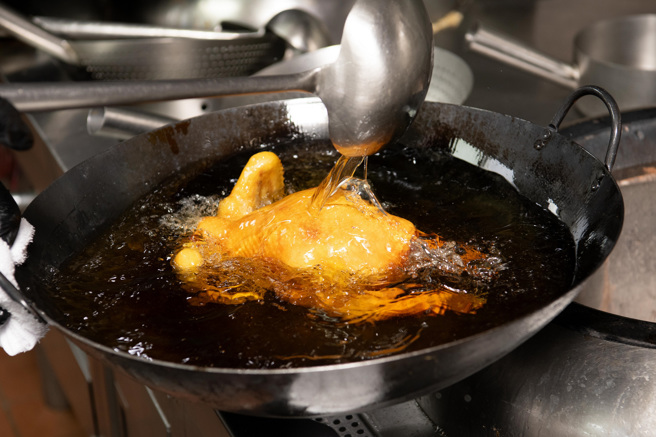 将风乾的全鸡持续淋上热油，直到外皮变得红润酥香。（摄影／李智为 ）