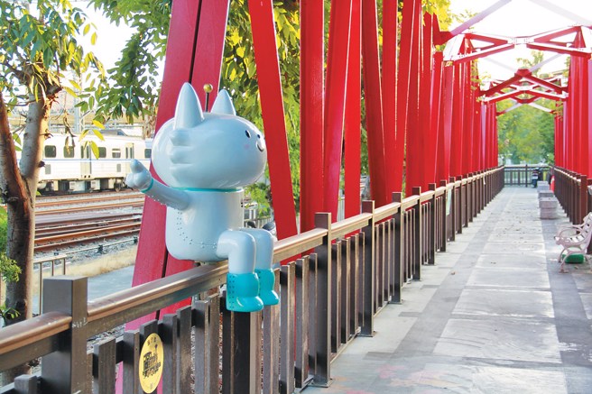 虹橋上的喵星人公仔「半半」指引遊客前往全台灣碩果僅存的扇形車庫。（圖／彰化市公所提供）
