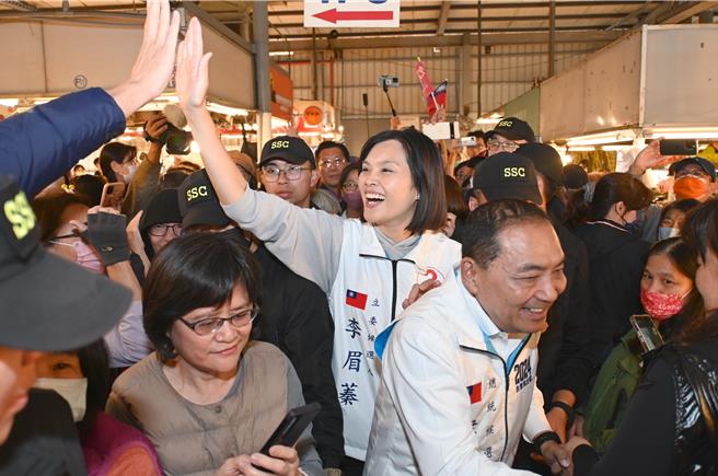 国民党总统候选人侯友宜（前右）10日到高雄左营黄昏市场拜票，立委候选人李眉蓁（后中）与民眾击掌。（林瑞益摄）