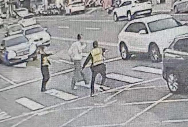 台中市东区街头，10日下午出现1名沈姓男子（中），持铁棍攻击人车事件，造成5人受伤送医，警方祭出辣椒水才将患有将精神障碍的沈男制伏，戒护就医。（王煌忠摄）