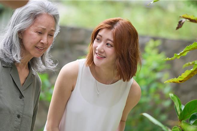 李璇（右）為了拍攝林逸欣新歌〈風的記憶〉，不惜淋雨拍攝。（鑫羽工作室提供）