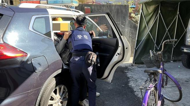 老翁臉色蒼白癱坐路邊，員警連忙將他抱上警車送返家。（警方提供）