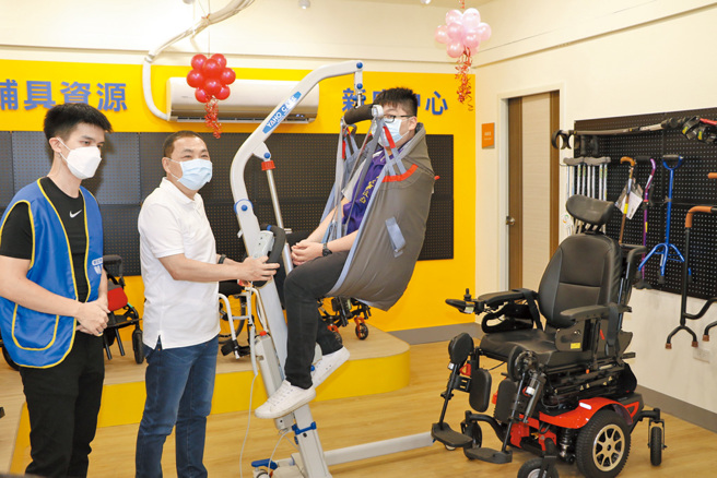 侯友宜（左二）实际操作移位机辅具，体验将示范重瘫者从轮椅上轻松移位。（图／新北市社会局提供）
