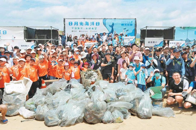 大手牵小手，大人们带领着活泼可爱的小朋友齐聚沙滩捡拾漂洋而来的垃圾。（图／日月光环保永续基金会提供）