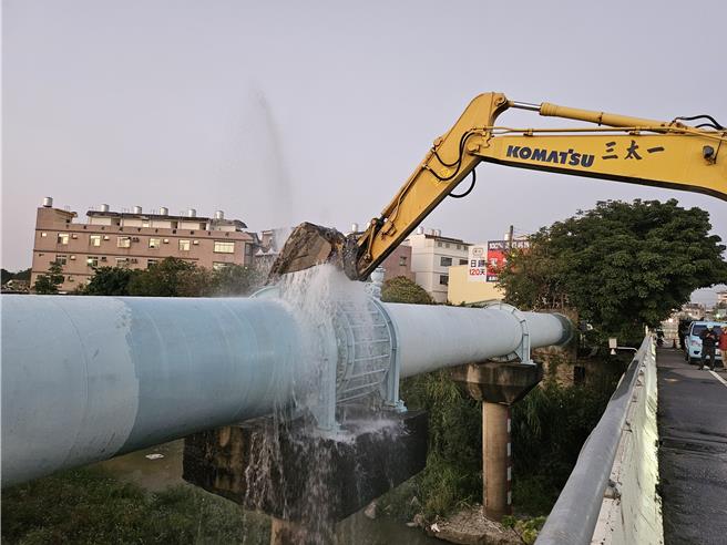 台水六区处派员到场以挖土机挖斗挡水，避免影响交通。（台水公司第六区管理处提供／曹婷婷台南传真）