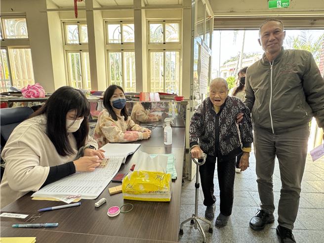 金门地区今早投票情形稍嫌冷清，不过有位103岁阿嬷(右二)一早就在家属搀扶下开心投下自己的手中的一票，令现场选务人员感到佩服。(于家麒摄)