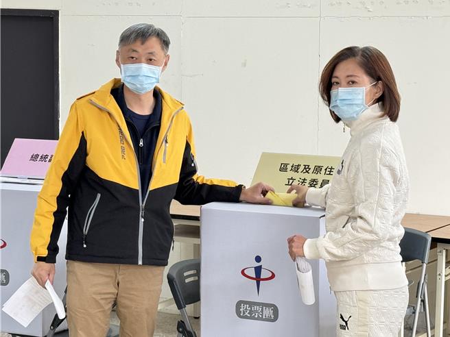 民眾党尚文凯(右)则与丈夫欧阳仪雄(左)甜蜜牵手赴欧厝投开票所完成投票。(于家麒摄)