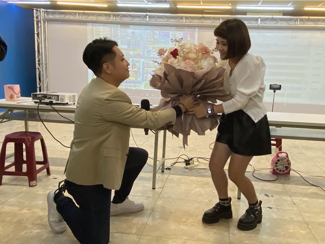 台中立委六選區國民黨候選人羅廷瑋（左）晚間自行宣布當選，他在當選談話後說要彌補遺憾，他欠太太一個求婚，當場捧花下跪高喊「老婆，我愛妳」。（陳淑芬攝）