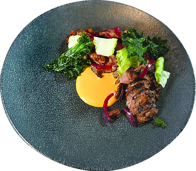 〈炙烧猪横膈膜〉是将猪横膈膜泡软去除筋膜后高温炙烧，搭配炭烤羽衣甘蓝、红洋葱呈盘，以豆腐乳酱提味。图／姚舜