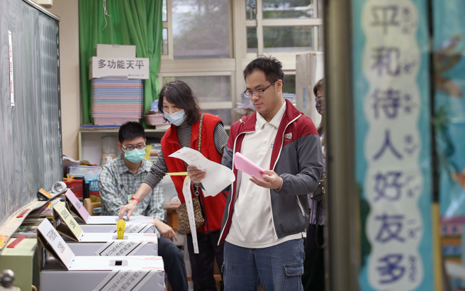 一名担任选务人员的女子在投开票所观察民眾的投票状况，她表示投票过程中最多人犯的错误是乱投递选票。（图／示意图，记者范扬光摄影）