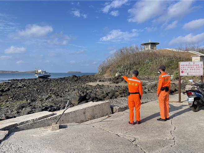 坐礁傾斜的昇滿興6號漁船，船上4名印尼船員先行登岸，岸巡人員則在旁警戒觀察。（許逸民攝）