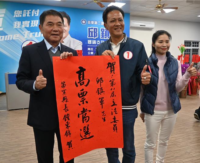 苗栗縣長鍾東錦昨天致贈紅榜祝賀邱鎮軍高票當選。（李京昇攝）