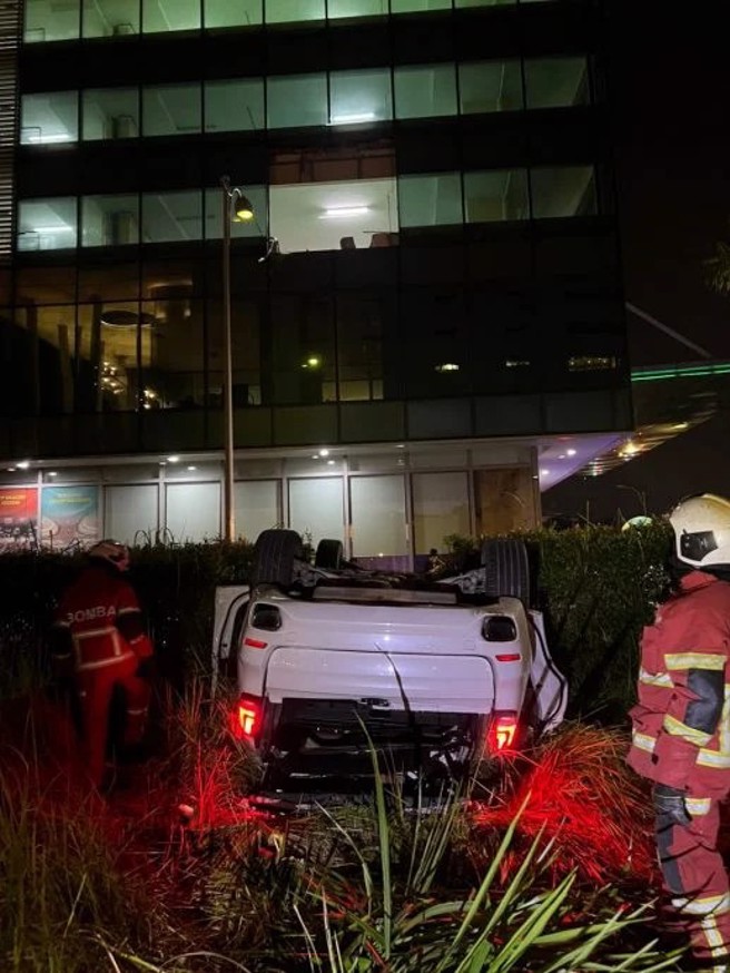 这辆白色BMW撞破3楼停车场围墙跟玻璃，直接从高空坠落，所幸驾驶轻伤。（图／翻摄星洲网）