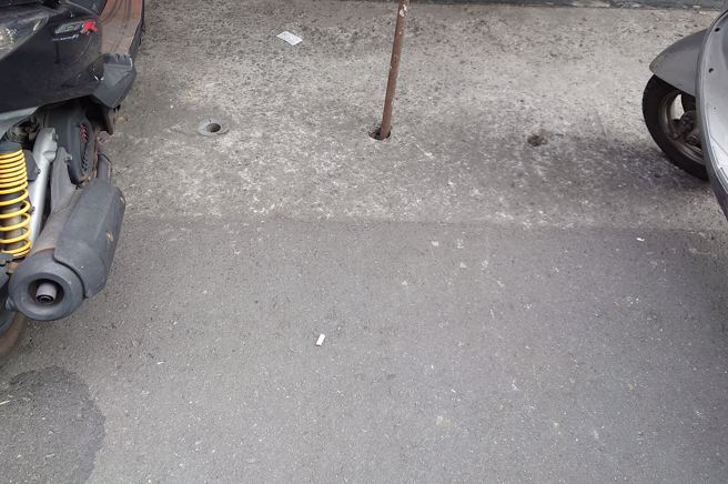 有網友拍到1處道路，發現有住家前水溝孔洞，插入1根鐵條疑似「佔車位」，讓他很生氣的表示「佔車位無所不用其極」。（圖／翻攝自臉書爆怨2公社）