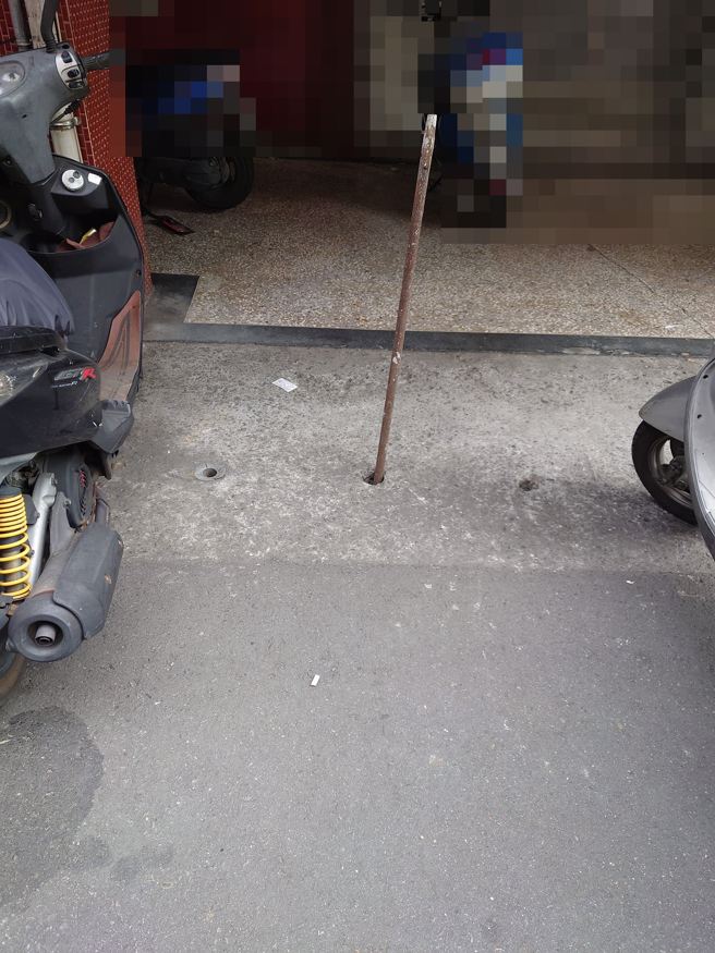 有網友拍到1處道路，發現有住家前水溝孔洞，插入1根鐵條疑似「佔車位」，讓他很生氣的表示「佔車位無所不用其極」。（圖／翻攝自臉書爆怨2公社）