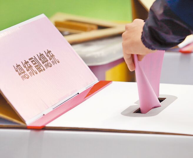 13日投票率71.86％，即便天氣晴朗，投票率卻未如想像中的高，圖為民眾正將總統副總統選票投入票匭。（范揚光攝）