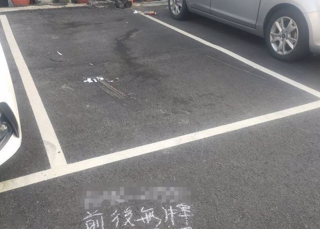 有网友在一处停车场看见空位的停车格，地下留下相关讯息「前后无牌...」，让他有些困惑「有什么故事？」。（图／翻摄自脸书路上观察学院）