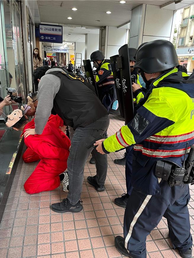 年关将近，基隆市警局第四分局、刑事警察大队及训练科邀请健身网红「健人盖伊」与药师、波波（图中红衣者）扮演歹徒，进行防抢演练，相当逼真。（基隆市警察局提供／徐佑升基隆传真）