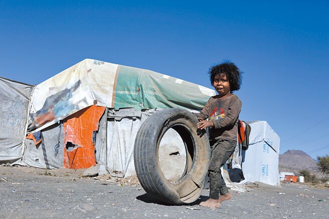 数十亿人因疫情、通货膨胀及战争被迫陷入财政困境，亿万富豪财富正高速成长。图为一名儿童在叶门北部郊区一个难民营推轮胎。（新华社）