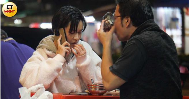 蔚荭萦和一名男子坐在小吃店共进晚餐，却是电话讲不停，而男伴则自顾自地喝完碗里的粥。（图／本刊摄影组）