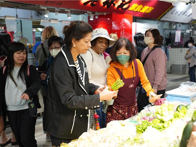 今日上午包括日本、瑞典、印度、聖露西亞、加拿大等國的駐台代表夫人，以及英國駐台副代表夫人等人，在台北市政府人員的帶領下，前往甫改建完成的南門市場添購年貨，沿途經過蔬果、溫體豬肉店以及漁店時，也有夫人直接購置。（黃敬文攝）