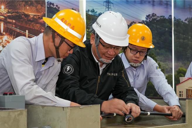 经济部次长暨台电代理董事长曾文生体验台电第一线人员现场抢修作业，亲自操作配电地下电缆的压接与绝缘处理作业。（台电提供）