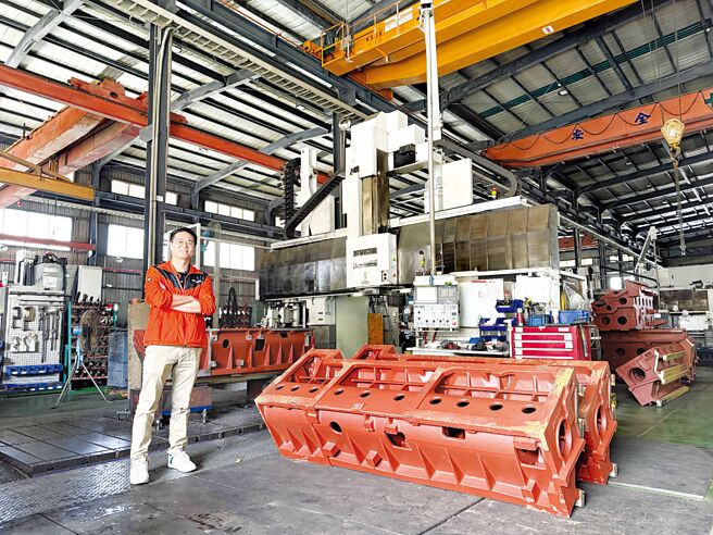 台稳董事长特助郑生懋与该公司机械加工部门内的三菱大型五面加工机及加工铸件。图／庄富安