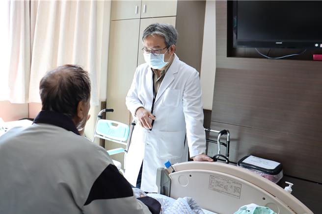 彰化八旬王姓老翁车祸后仍服用含抗凝血剂药物而造成血胸，卫福部彰化医院胸腔创伤微创重建中心主任林聿腾（右）为其手术后探视其恢復状况。（彰化医院提供／孙英哲彰化传真）