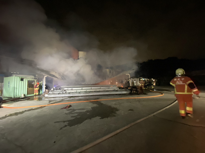 2層鐵皮建築的鴿舍遭惡火吞噬崩塌，消防隊在現場搶救中。（翻攝畫面）