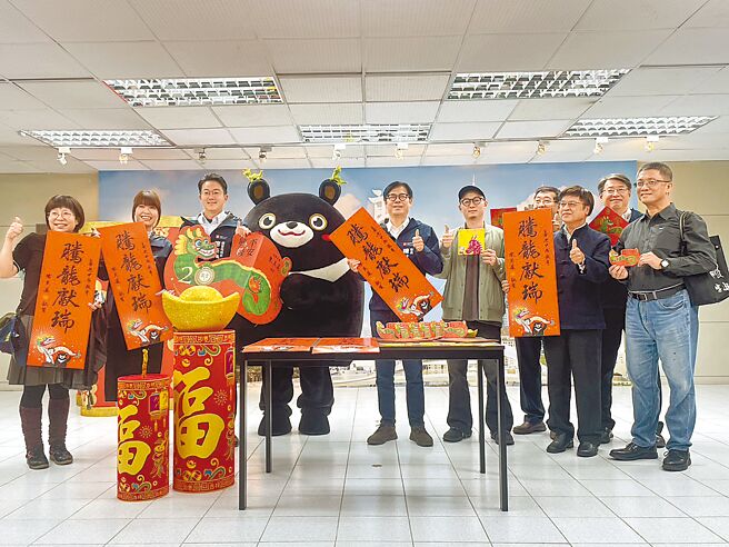 高市府18日舉辦「開箱高雄市龍年新春小物」記者會，由高雄市長陳其邁（左五）攜手觀光大使「高雄熊」（左四）向民眾拜早年，並介紹龍年新春小物。（洪浩軒攝）