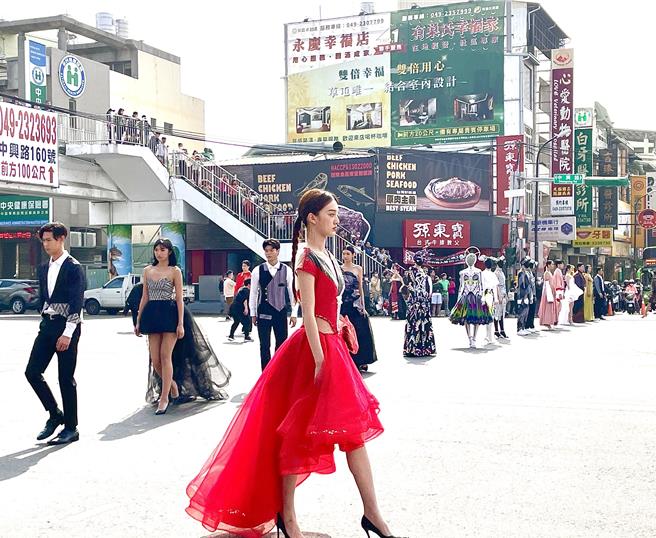 南投县原民局20日上午在草屯镇中兴路、太平路2段十字路口进行「名模街头快闪时装秀」，吸引大批民眾驻足观赏。（民眾提供／杨静茹南投传真）