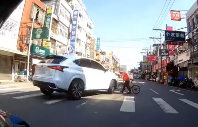 1名阿妇人脚踏车走在斑马线上要过马路，不料，1辆休旅车疑似A住挡住，竟没发现行人抢着左转，差点撞上妇人。（ 图／ 翻摄自「WoWtchout-地图型行车影像分享平台」）