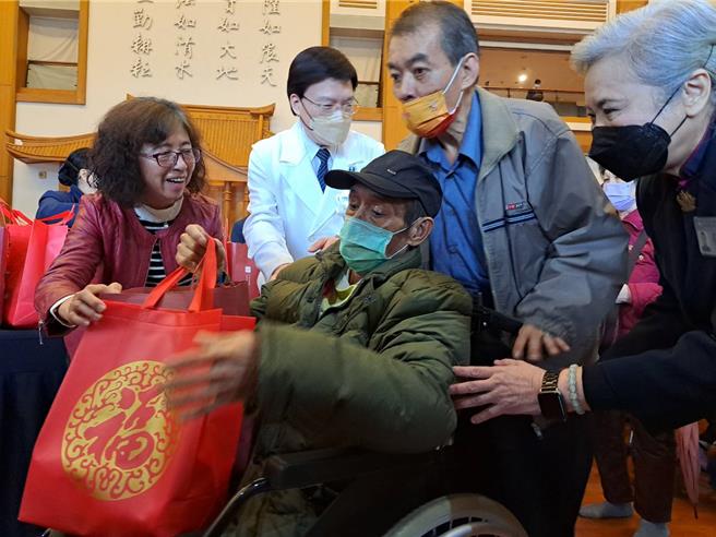 社会局副局长许秀能和慈济台北医院院长赵有诚一起致赠福袋给弱势家庭。（新北市社会局提供）