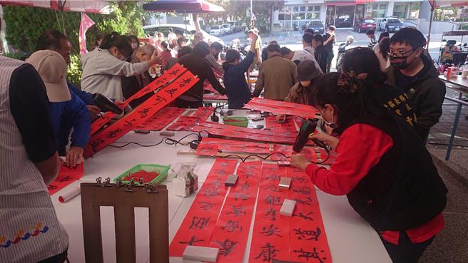 台南市北區光武里活動中心21日舉辦贈春聯活動，湧入許多眷村居民索取。（程炳璋攝）