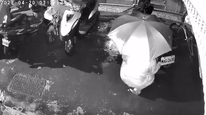 男子都在雨天犯案，持利器破坏轮胎跟坐垫，半夜戴口罩墨镜，利用雨伞遮蔽监视器拍摄。（杨小姐提供）