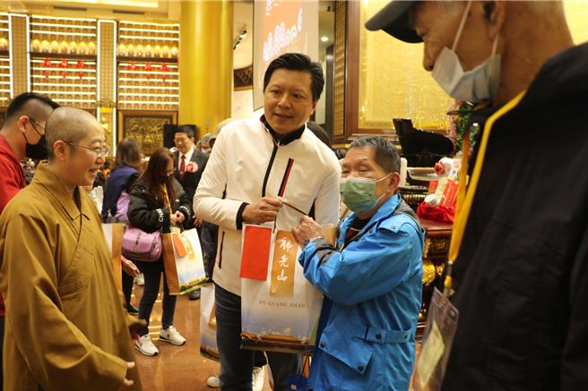 2024年1月21日新北市／副市长朱惕之和金光明寺住持觉培法师一起致赠福田金和福袋给参加的家户。（新北市社会局提供／刘玮晴新北传真）