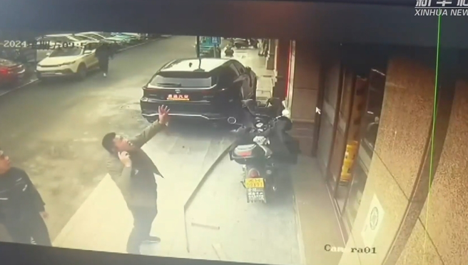 男子路过惊见男童坠楼，边打电话边出手相救。（图／翻摄新华社）