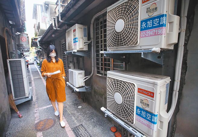 在野党立委抨击，电价飙涨是错误能源政策造成，不同意政府只想一味补助台电。图为民眾经过许多冷气室外机。（本报资料照片）