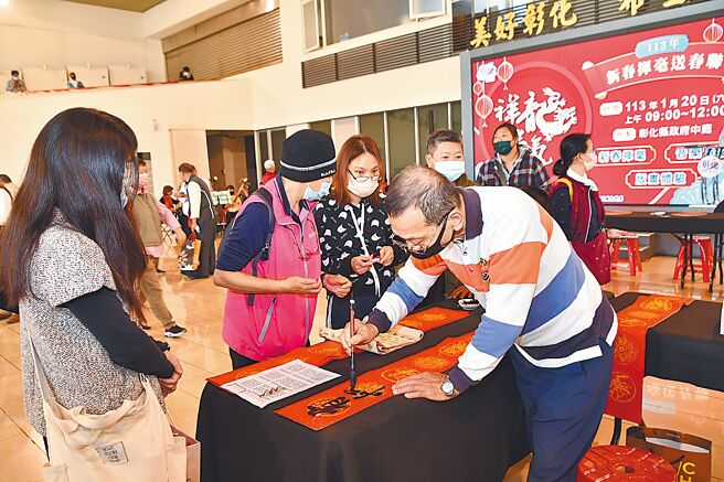 彰化县文化局为迎接农历新春佳节，20日在彰化县政府中庭举办新春挥毫送春联，民眾近距离欣赏书法名家挥毫。（孙英哲摄）