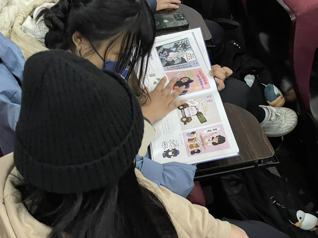 给学生阅读刑事局制作的反诈骗手册(图/新北市政府警察局提供)